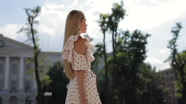 Уповільнення красивої елегантної жінки в одязі, що йде в літньому місті — стокове відео