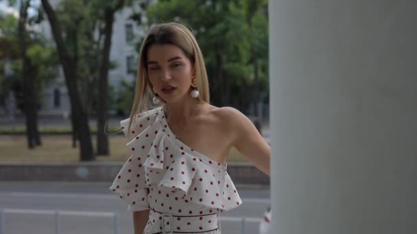 Hermosa mujer elegante en vestido posando en la ciudad de verano — Vídeo de stock