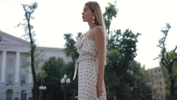 Hermosa mujer elegante en vestido caminando en la ciudad de verano — Vídeo de stock