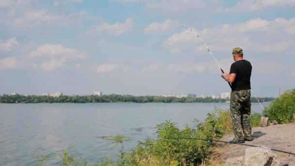 Рыбак ловит рыбу на реке — стоковое видео