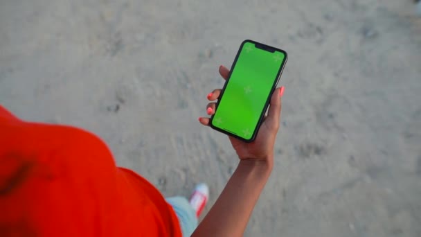 POV, θηλυκό κρατώντας κενή πράσινη οθόνη του smartphone περπάτημα στην παραλία — Αρχείο Βίντεο