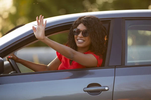 Mujer feliz conductor sentado en salón de coches saludando de la mano — Foto de Stock