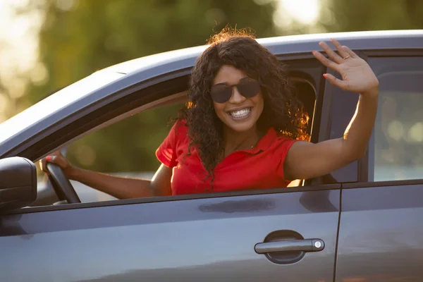 Mujer feliz conductor sentado en salón de coches saludando de la mano — Foto de Stock
