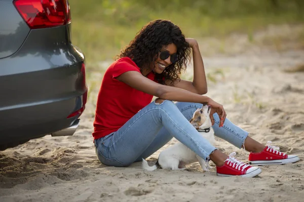 Mujer jugar con su perro sentado cerca de coche — Foto de Stock