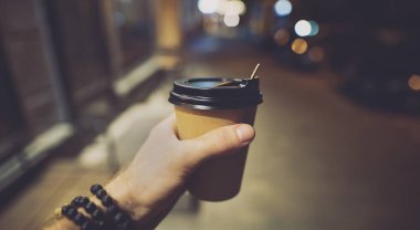 Pov, kahve veya latte kağıt fincan gece bir erkek elinde