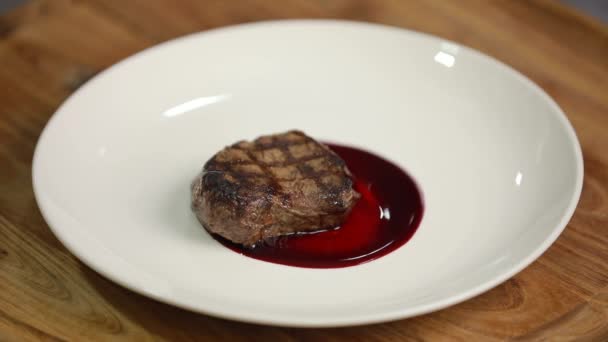 Σεφ που σερβίρει πιάτο με κρέας σε ένα πιάτο — Αρχείο Βίντεο