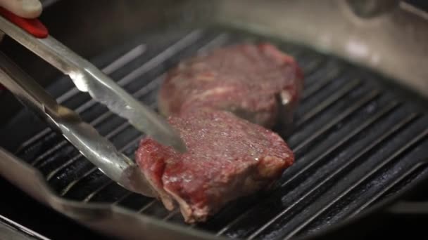 Chef vira carne em uma panela de ato de fritar — Vídeo de Stock