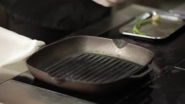 Şef bir tava üzerine et koydu