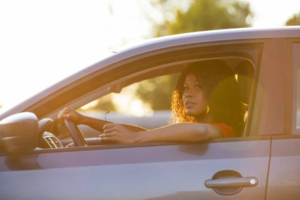 Mujer feliz conductor sentado en el salón de coches al atardecer — Foto de Stock
