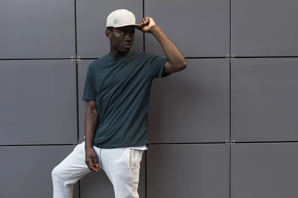 Afrikai férfi, üres póló, ami a fal mellett pózol — Stock Fotó