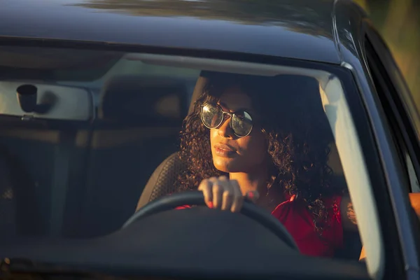 Mujer feliz conductor sentado en el salón de coches al atardecer — Foto de Stock