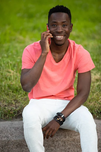 Akıllı Telefonda konuşan yaşayan mercan t-shirt Afrikalı Amerikalı adam — Stok fotoğraf