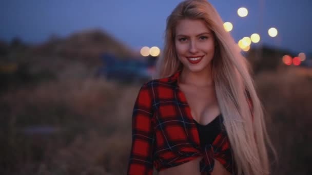 Attraktive sexy Frau, die in der Abenddämmerung auf einem Feld spaziert — Stockvideo