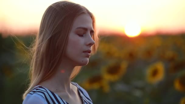 Portret van meisje in het veld bij zonsondergang draaien gezicht — Stockvideo