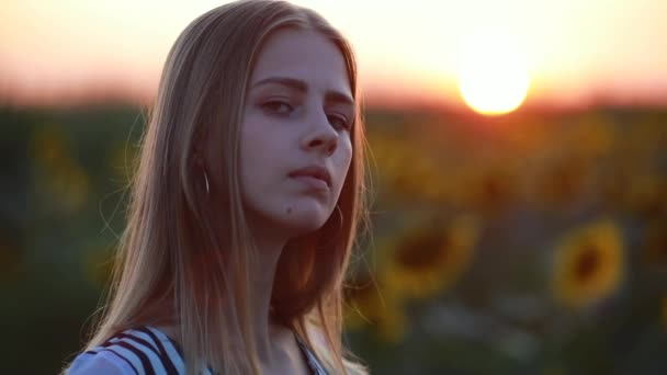 Portret van meisje in het veld bij zonsondergang draaien gezicht — Stockvideo