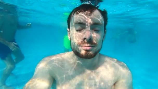 Человек моргает глазами под водой в бассейне, замедленная съемка — стоковое видео