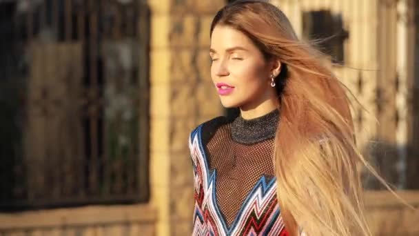 Gyönyörű divatos női modell séta a napfényes városban — Stock videók