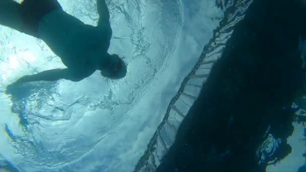 男の水泳選手は、プールの底からアクションカメラを取ります — ストック動画