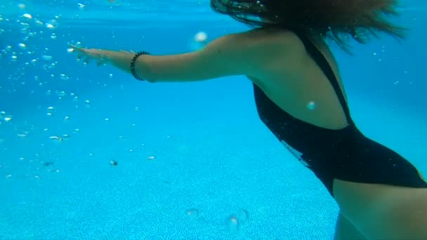 Женщина плавает в бассейне под водой — стоковое видео