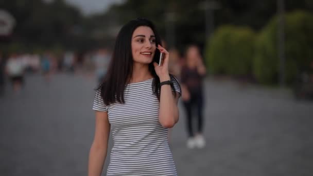Beautiful woman talking by phone in city — Stock Video