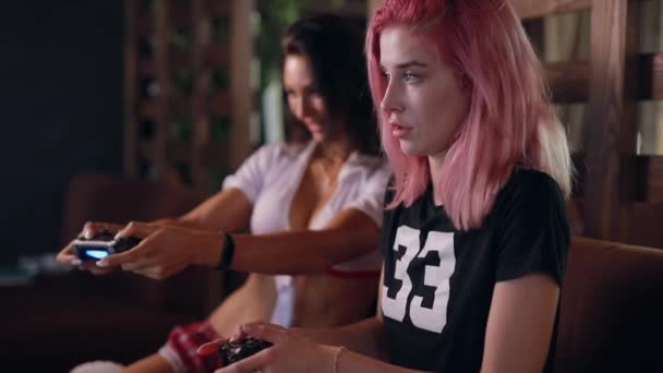 Duas meninas sexy jogando jogo de tv segurando joysticks — Vídeo de Stock