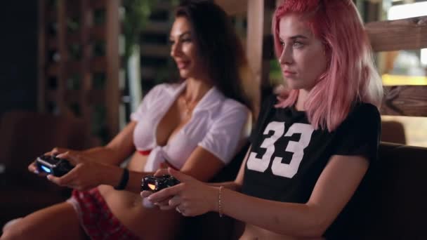 Joysticks tutarak tv oyunu oynayan iki seksi kız — Stok video