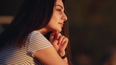 Güzel kadın rahatlatıcı oturan ve gün batımına bakarak