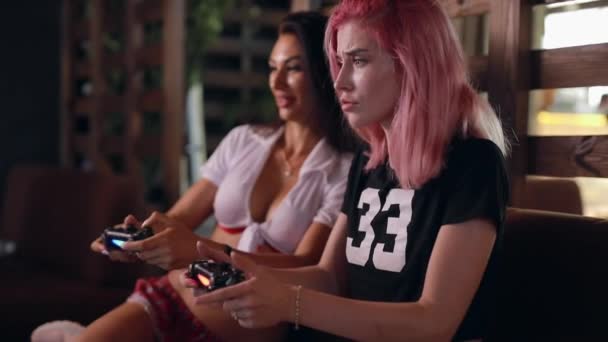 Twee sexy meiden spelen TV Game Holding joysticks — Stockvideo