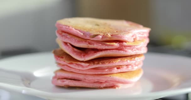 Zet de bereide roze pannenkoeken in de kom — Stockvideo