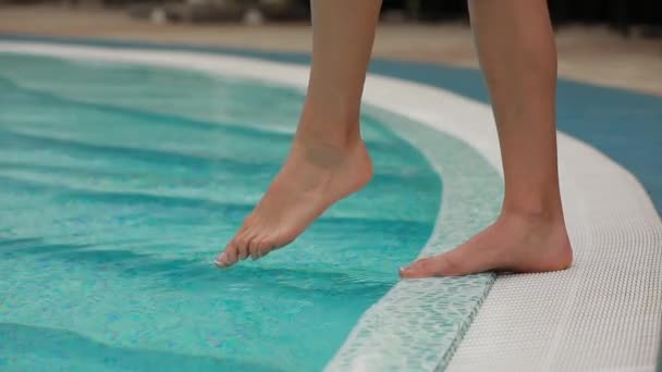 Patas femeninas que miden la temperatura del agua en la piscina — Vídeos de Stock