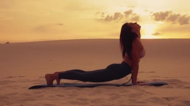 Kadın gün batımında çölde yoga egzersiz yapmak