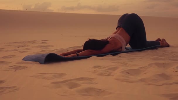 Femme faire de l'exercice de yoga dans le désert au coucher du soleil — Video