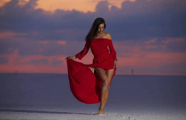 ผู้หญิงแฟชั่นสวย โพสในชุดแม็กซี่สีแดงบนทะเลทราย . — ภาพถ่ายสต็อก