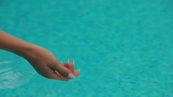 Nerozpoznatelná žena strká ruku do bazénu — Stock video