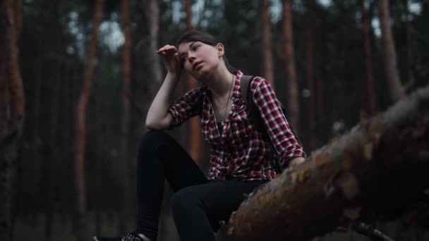 Donna stanca ma felice seduta sul tronco d'albero nella foresta e rilassante — Video Stock