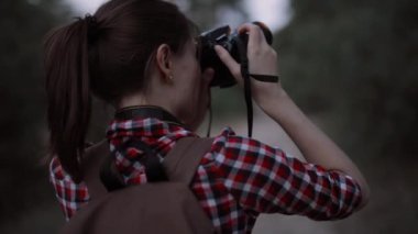 Turist kadın fotoğrafçı ormanda yürüyüş yapıyor.