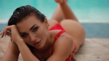 Yüzme havuzu yakınında kırmızı mayo poz seksi baştan çıkarıcı kadın
