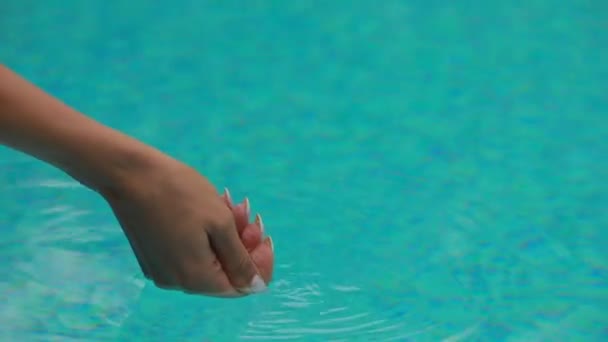 Mulher irreconhecível colocando a mão em uma piscina — Vídeo de Stock