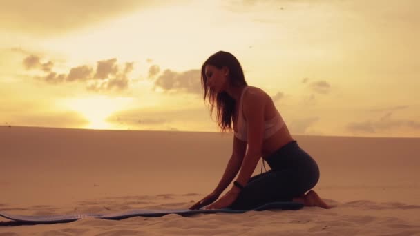 Femme faire de l'exercice de yoga dans le désert au coucher du soleil — Video