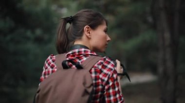 Turist kadın fotoğrafçı ormanda yürüyüş yapıyor.