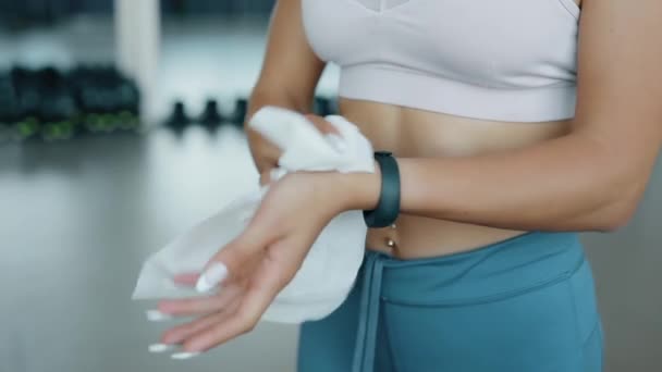 Woman wipes hands with a wet napkin in a fitness center — Stock Video