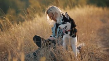Kadınlar köpekle doğada oynarlar. Dertsiz tasasız evcil hayvanla geçirilen yaz zamanı.