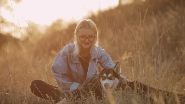 Vrouw speelt met hond op de natuur. Zorgeloos genieten van een zomertijd met huisdier. — Stockvideo
