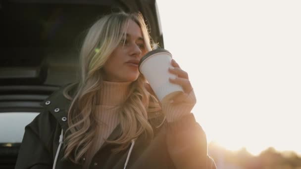 Mujer disfruta de otoño beber té caliente y comer galletas cerca del coche — Vídeo de stock