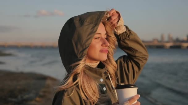 Mujer bebiendo té de pie cerca del río en el día de otoño — Vídeos de Stock