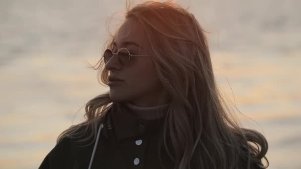 Retrato de mujer con estilo en gafas de sol de pie cerca del río — Vídeos de Stock