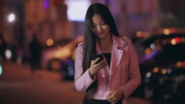 Asyalı kadın cep telefonundan mesaj gönderiyor.