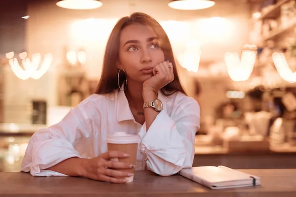 Surullinen nainen istuu kahvilassa — kuvapankkivalokuva