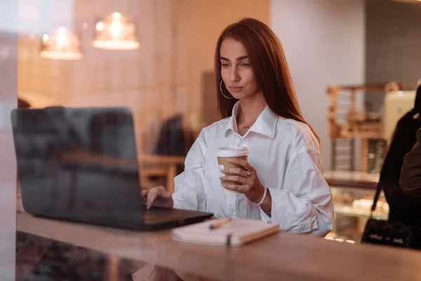 Жінка працює ноутбуком в кафе — стокове фото