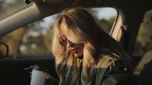 Egy nő forró teát iszik egy autóban. — Stock videók